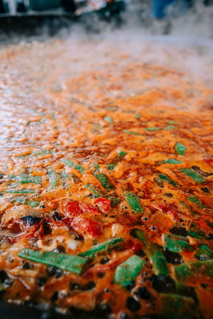Paella wird live in der gro&szlig;en Pfanne gekocht